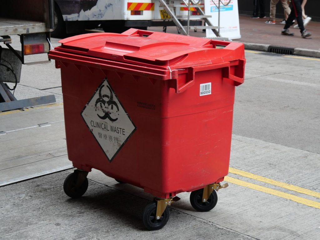 The Art of Drawing Readers In: Your attractive post title goes here A red clinical waste bin labeled with biohazard symbol on a city street indicating proper waste management.