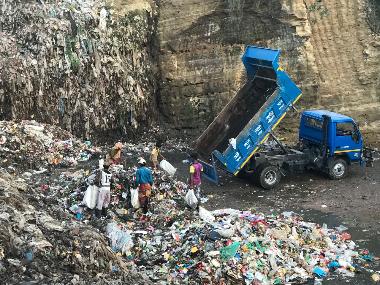 Workers sorting waste at a landfill in Chattogram, Bangladesh, highlighting environmental and pollution issues.