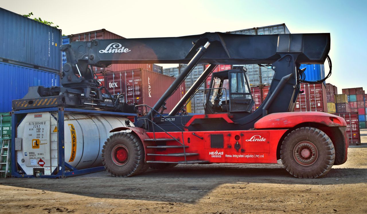 Mastering the First Impression: Your intriguing post title goes here Forklift operating at a cargo yard, moving large containers efficiently.