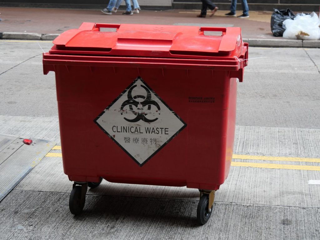 Crafting Captivating Headlines: Your awesome post title goes here A red wheeled bin labeled for clinical waste management on a city street.